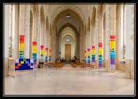 The colourful banners amongst the giant pillars of Guildford Cathedral in the South of England. This magnificent building plays host to local artists as well as its worshipping congregation.